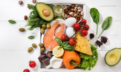 Ketogenic low carbs diet - food selection on white wooden background. Balanced healthy organic ingredients of high content of fats. Nutrition for the heart and blood vessels. Meat, fish and vegetables.